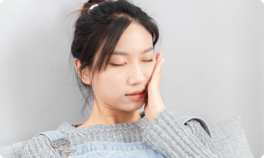 頬に手をかざす女性