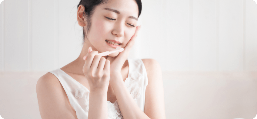 頬に手をかざす女性