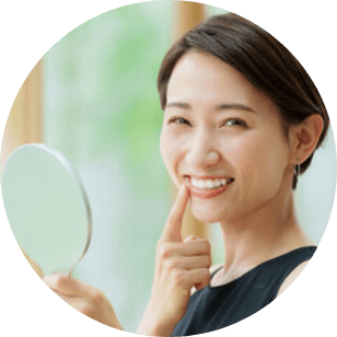 歯に手を当て白さに喜ぶ女性